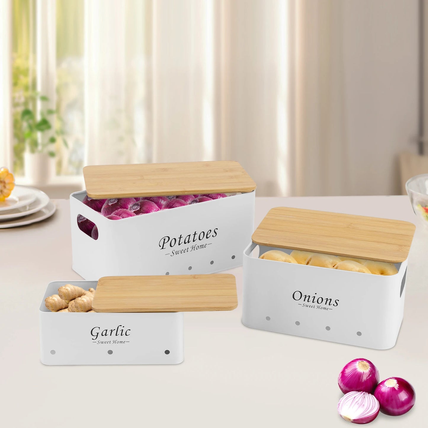 Weiße Aufbewahrungsboxen für Kartoffeln, Zwiebeln und Knoblauch mit Bambusdeckeln auf Tisch arrangiert.