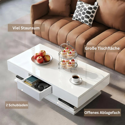 Weißer Couchtisch im Wohnzimmer mit viel Stauraum, ausgezogenen Schubladen und großer Tischfläche vor Sofa.
