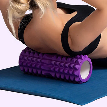 Anwendung der Foamroller-Rolle für den Rücken – lila Rolle auf Yogamatte.