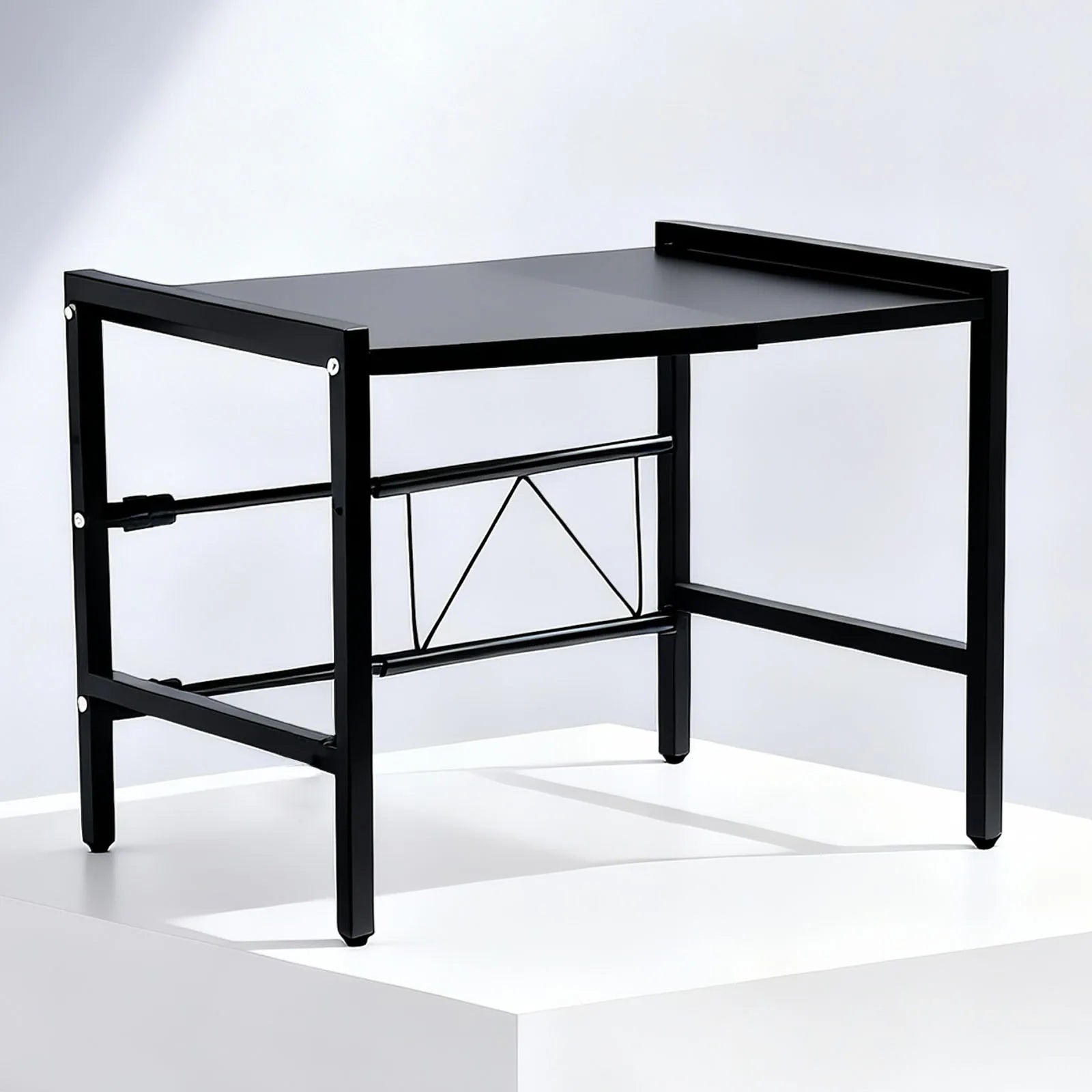 Schwarzes Mikrowellenregal als Studioaufnahme vor hellem Hintergrund.