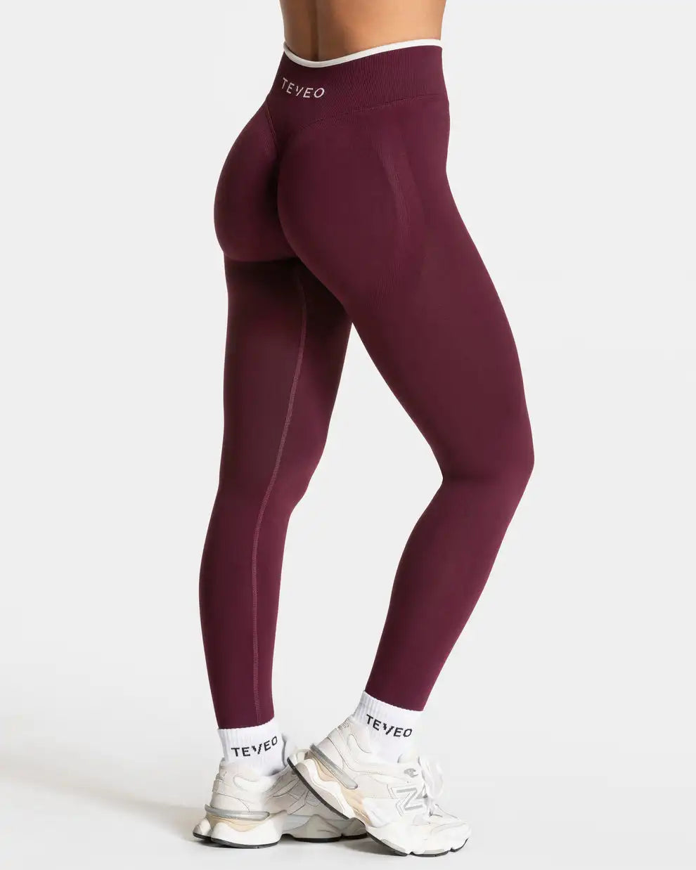 Nahtlose Sportleggings in Bordeauxrot in Rückansicht an einem Model getragen.