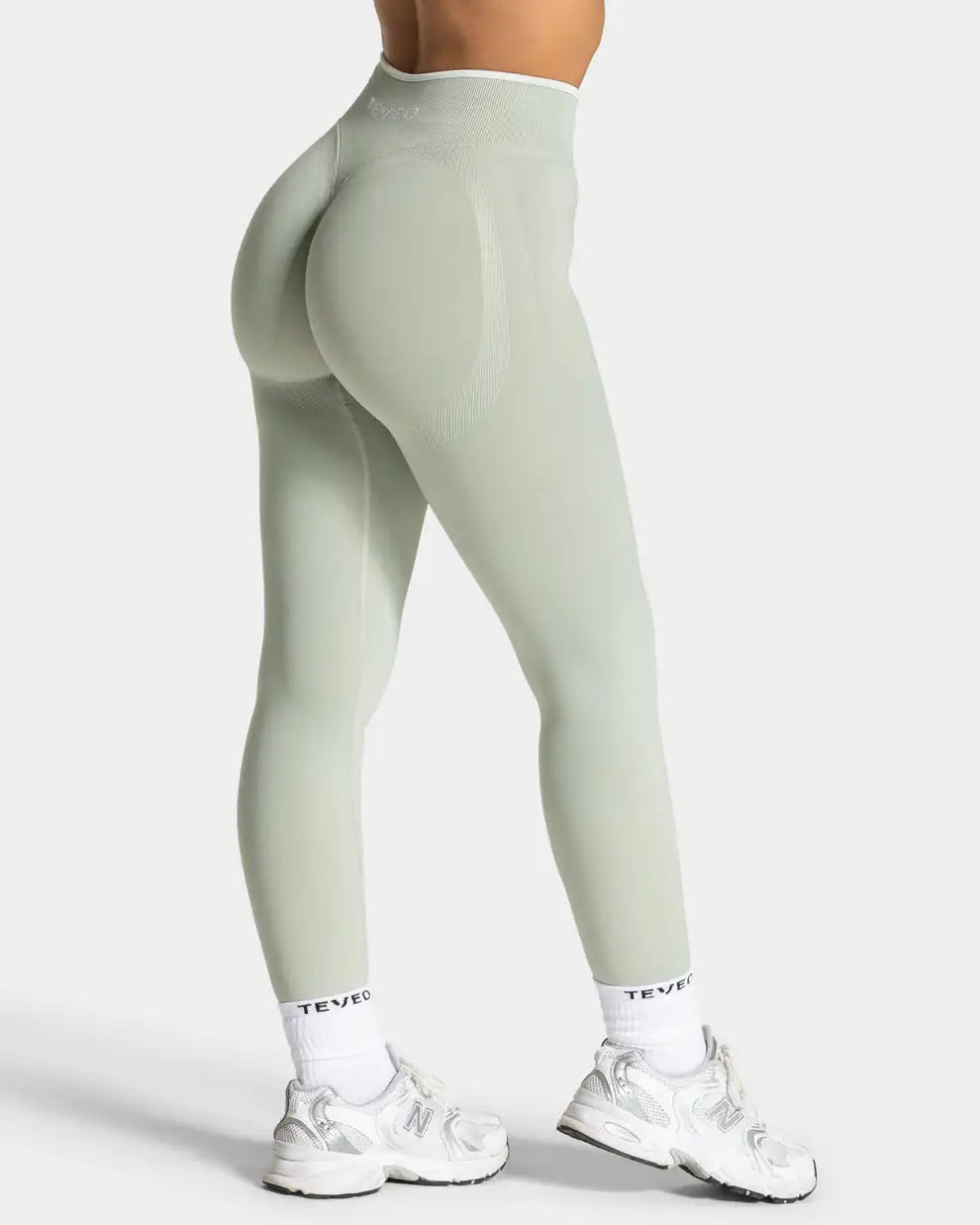 Nahtlose Sportleggings in Hellgrün in Rückansicht an einem Model getragen.