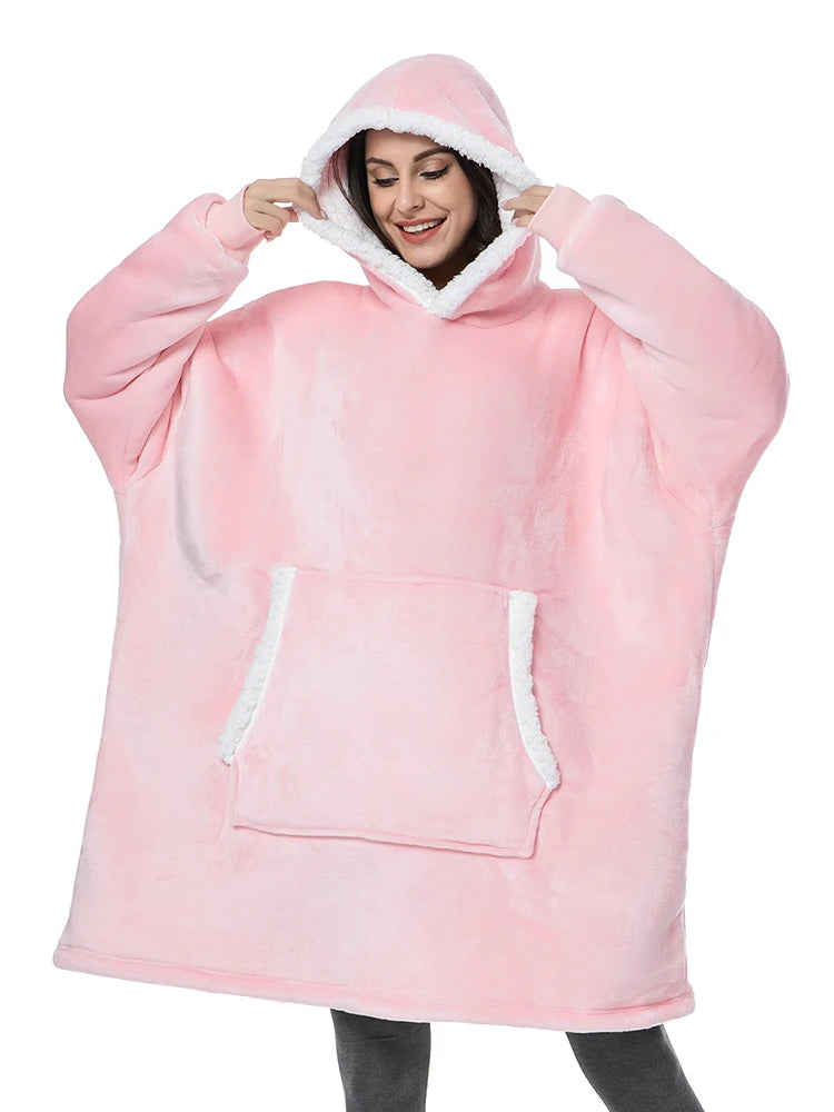 Frau trägt oversized Hoodie Decke in Rosa mit Kapuze und gemütlicher Fronttasche