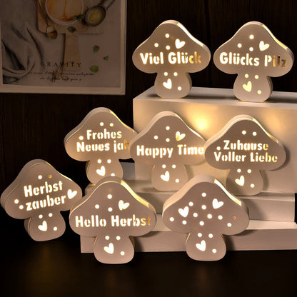 Mehrere beleuchtete Pilzfiguren aus Gips mit verschiedenen Schriftzügen wie Viel Glück, Zuhause Voller Liebe, Happy Time und Hello Herbst
