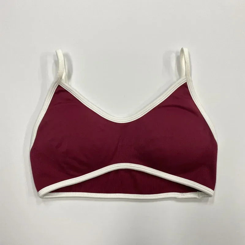 Bordeauxfarbener nahtloser Damen Sport-BH mit weißen Abschlüssen und schmalen Trägern auf neutralem Hintergrund.