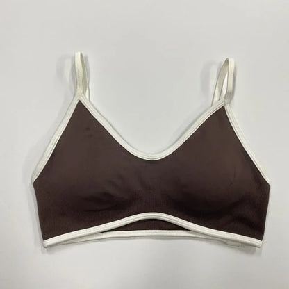 Brauner nahtloser Damen Sport-BH mit weißen Abschlüssen und schmalen Trägern auf neutralem Hintergrund.