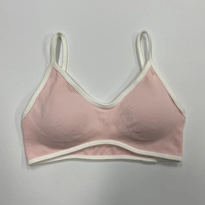 Alt-Text: Rosafarbener nahtloser Damen Sport-BH mit weißen Abschlüssen und schmalen Trägern auf neutralem Hintergrund.