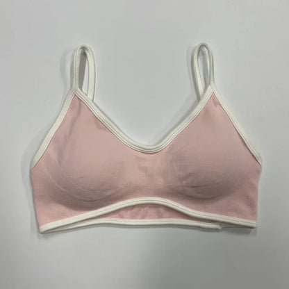 Alt-Text: Rosafarbener nahtloser Damen Sport-BH mit weißen Abschlüssen und schmalen Trägern auf neutralem Hintergrund.