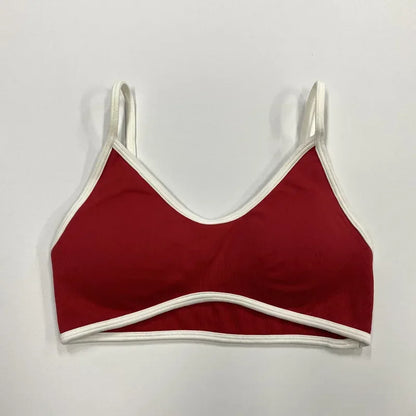 Roter nahtloser Damen Sport-BH mit weißen Abschlüssen und schmalen Trägern auf neutralem Hintergrund.
