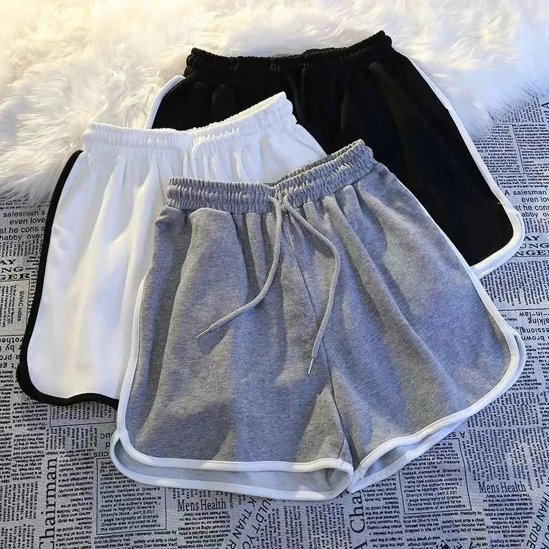 Damen Sport Shorts in Grau, Weiß und Schwarz mit elastischem Bund und Kontrastnähten.