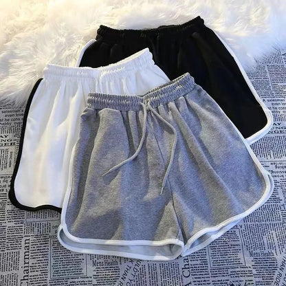 Damen Sport Shorts in Grau, Weiß und Schwarz mit elastischem Bund und Kontrastnähten.